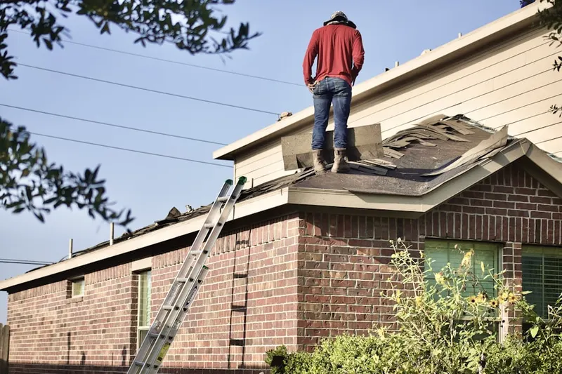 Professional roofer working on a residential roof in Ward